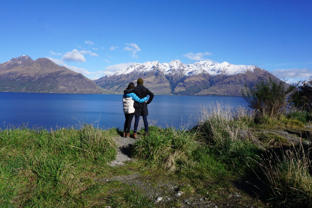 A couple hugging and looking at the New Zealand mountains