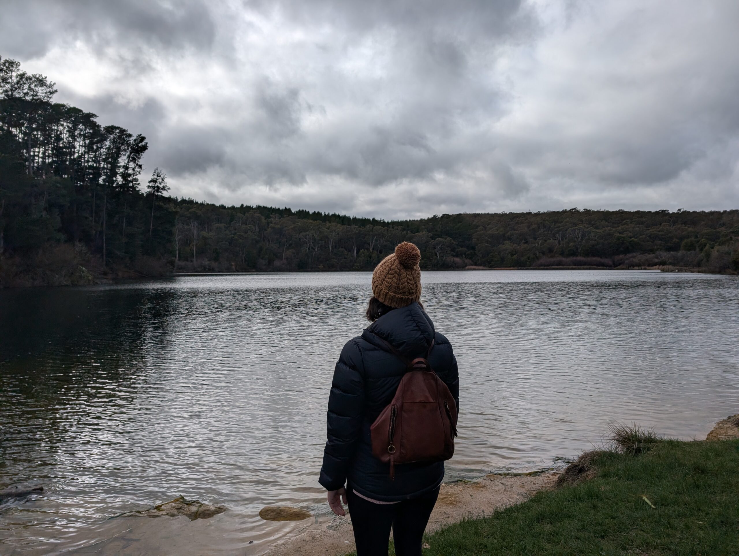 Woman looking out to a lake in winter